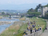 遠足で犀川の河原を歩く小学生たち